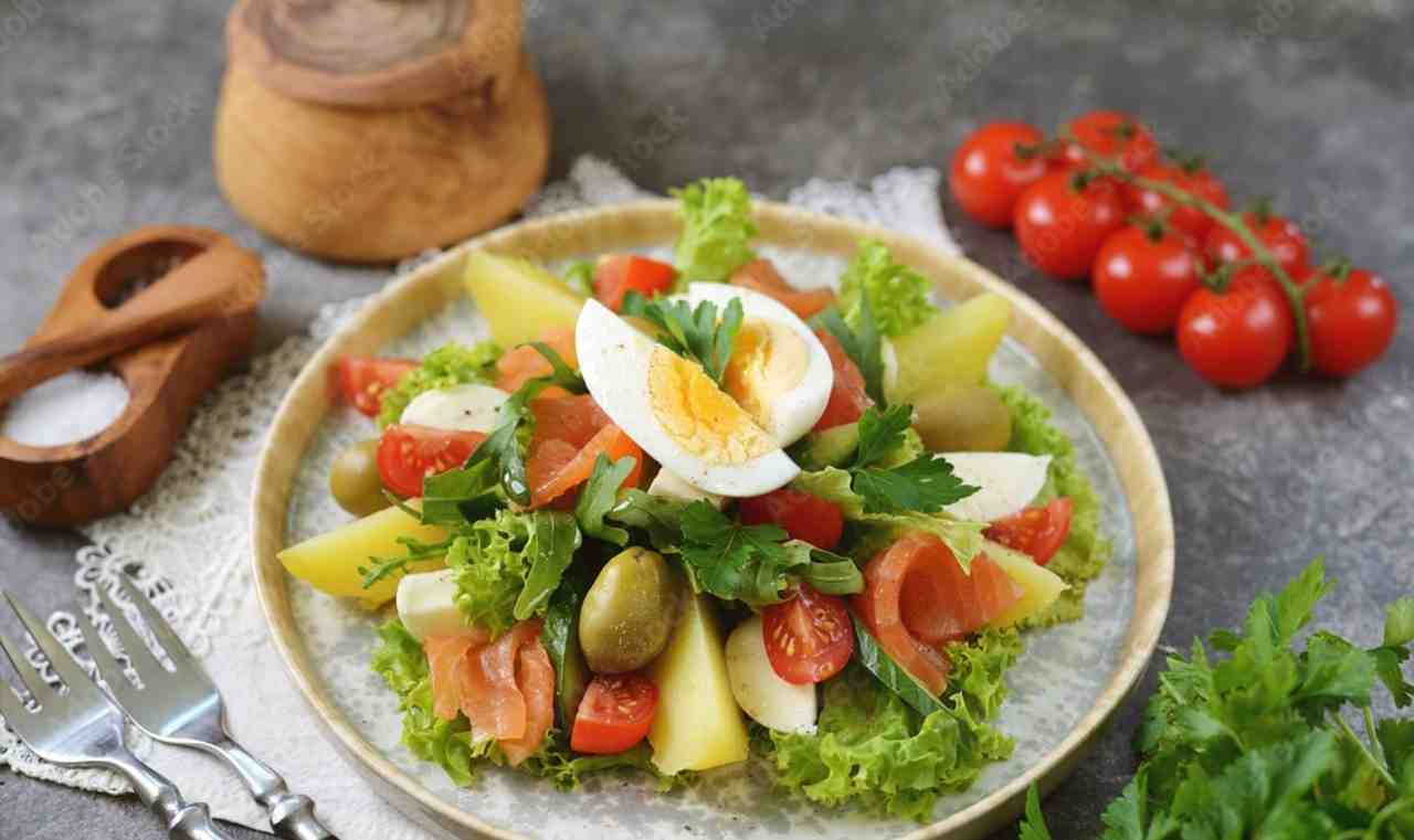 Insalata di salmone affumicato con patate, pomodorini, olive verdi e aggiunta di uovo sodo 